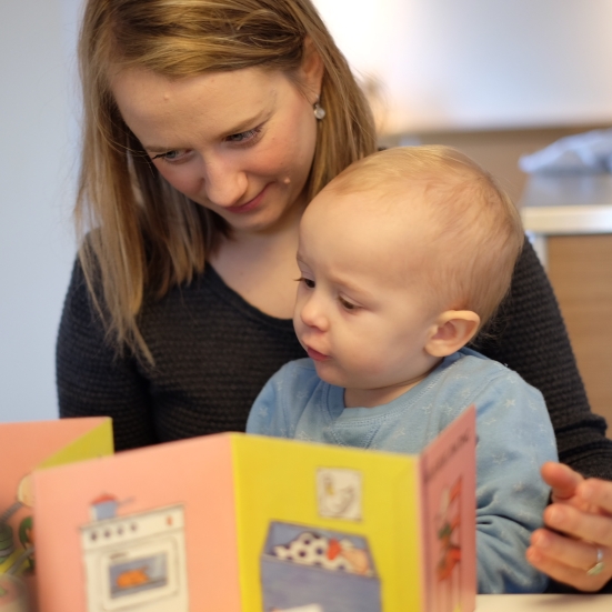 Mor og søn sidder sammen og læser i billedbog