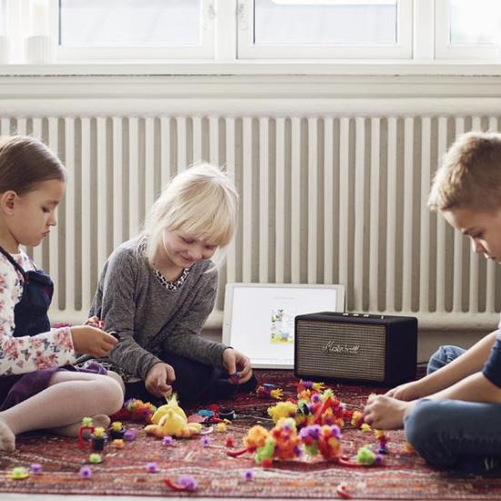 3 børn sidder og bygger Lego, mens de hører lydbog via højtaler