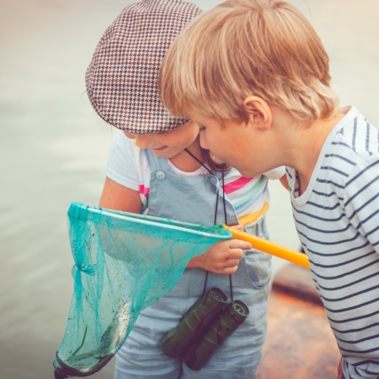 To børn kigger på dyr i et fiskenet