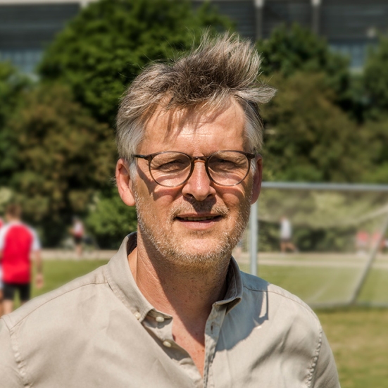 Foto af Morten Bruun med fodboldbane i baggrunden