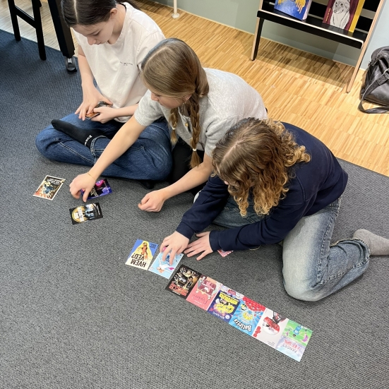 Tre piger, der sidder med bogforsider