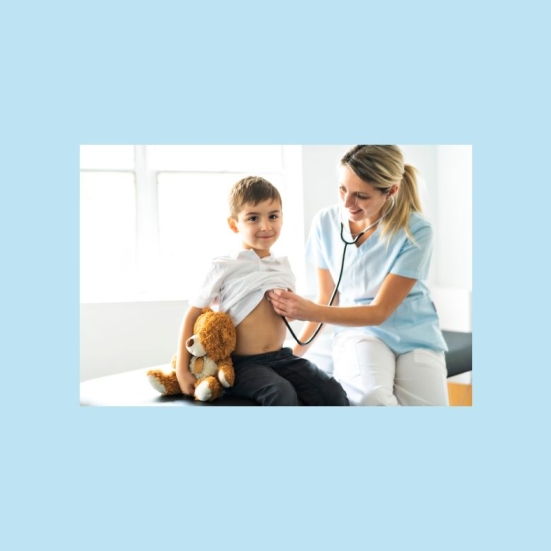 Et billede af en dreng med bamse, der bliver lyttet på hjertet med et stetoskop af en kvindelig læge.