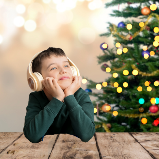 dreng med lydbog foran juletræ