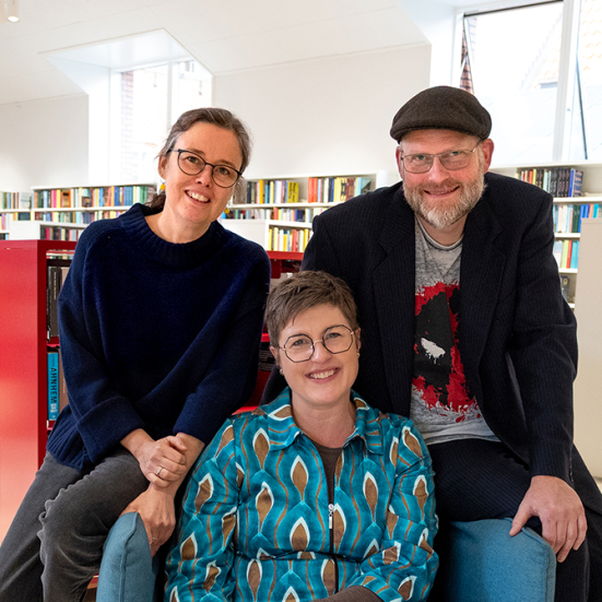 Foto af Anne, Frederik og Britt i biblioteksrummet