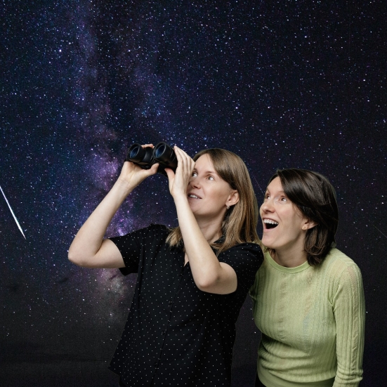 To personer står og kigger i stjernekikkert