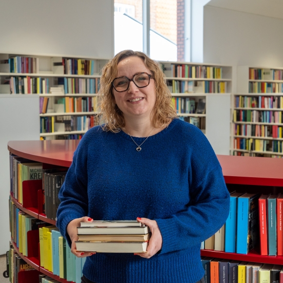 Ditte står med en bogstak 