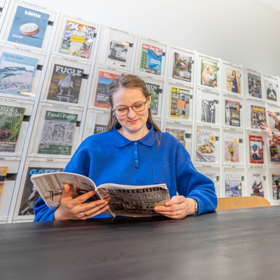 Kvinde der læser i et magasin på Silkeborg Bibliotek