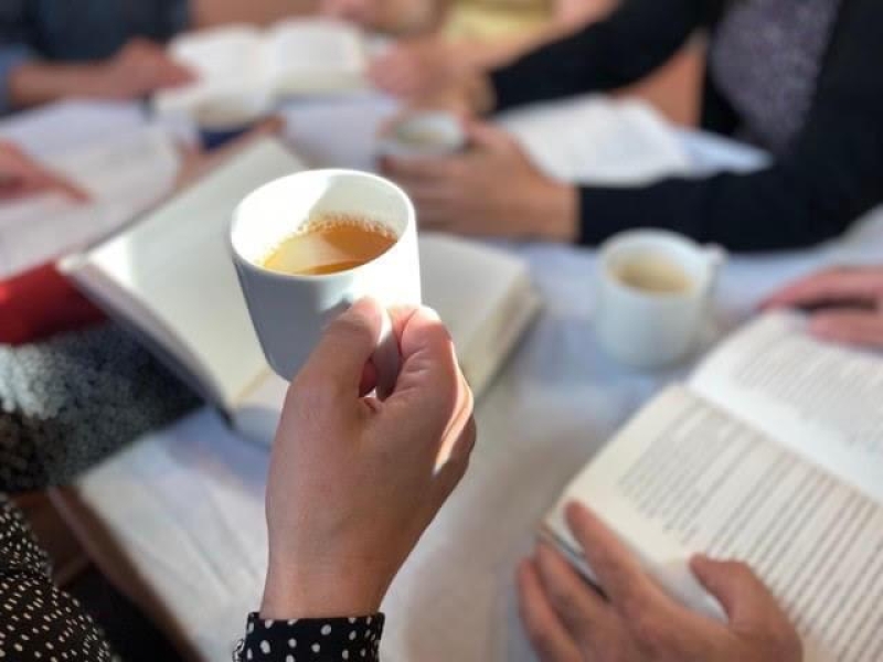 Foto af en kaffekop og en række åbne bøger