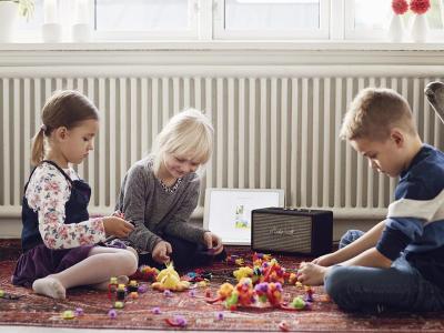 3 børn sidder og bygger Lego, mens de hører lydbog via højtaler