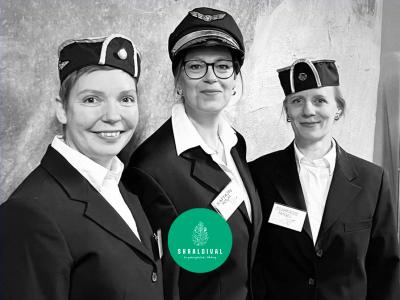 Tre smilende kvinder i pilotuniformer