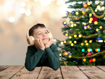 dreng med lydbog foran juletræ