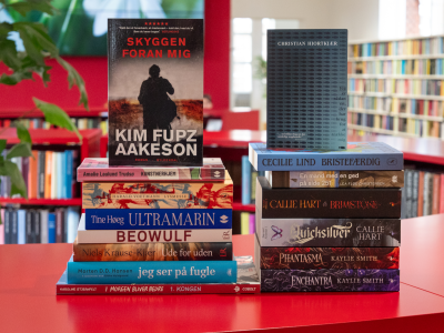 Foto af en stak bøger på rød og grøn baggrund