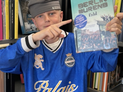 Dreng, der peger på en bog