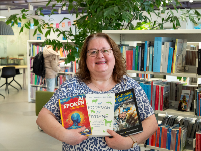 Billede af bibliotekar Ulla, som holder tre bøger. 