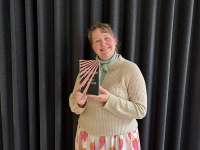 Litteraturformidler Imone Kramer holder bogforside med "Den fremmede"
