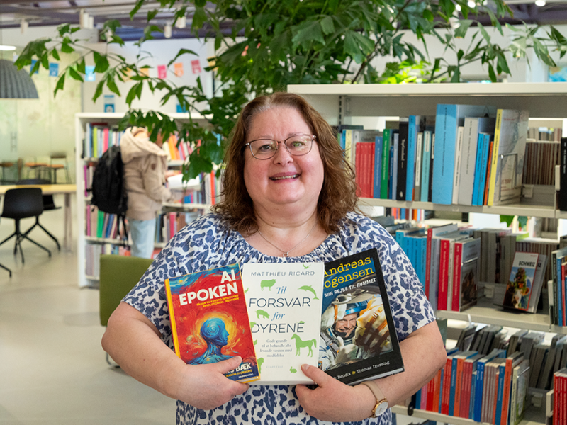 Billede af bibliotekar Ulla, som holder tre bøger. 