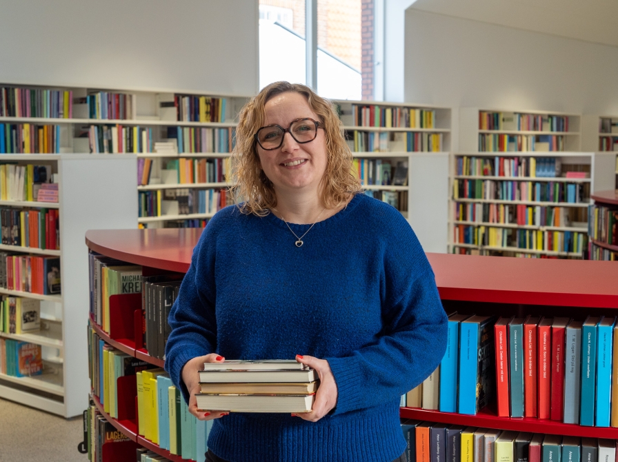 Ditte står med en bogstak 