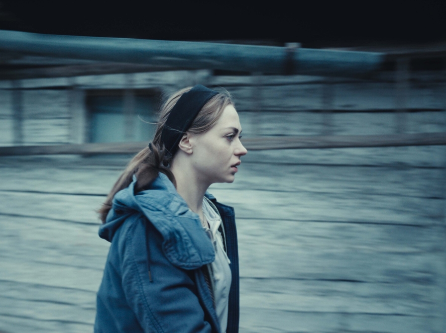 gående kvinde, går ved siden af et skur