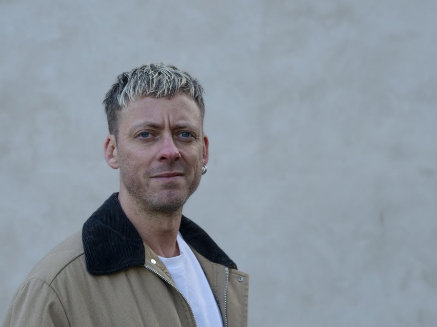 Forfatteren Theis Ørntoft foran en grå mur