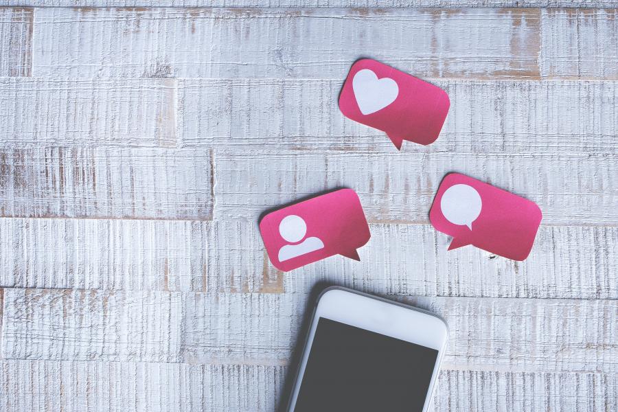 smartphone med ikoner for samtale, venskaber og likes