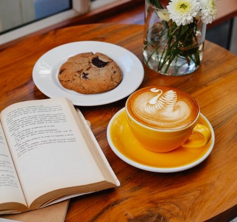 En kop kaffe og bog på et bord