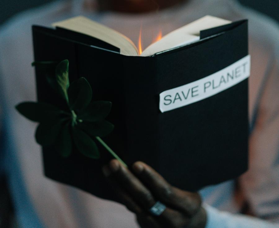 Bog med teksten 'Save Planet' med flammer stående ud