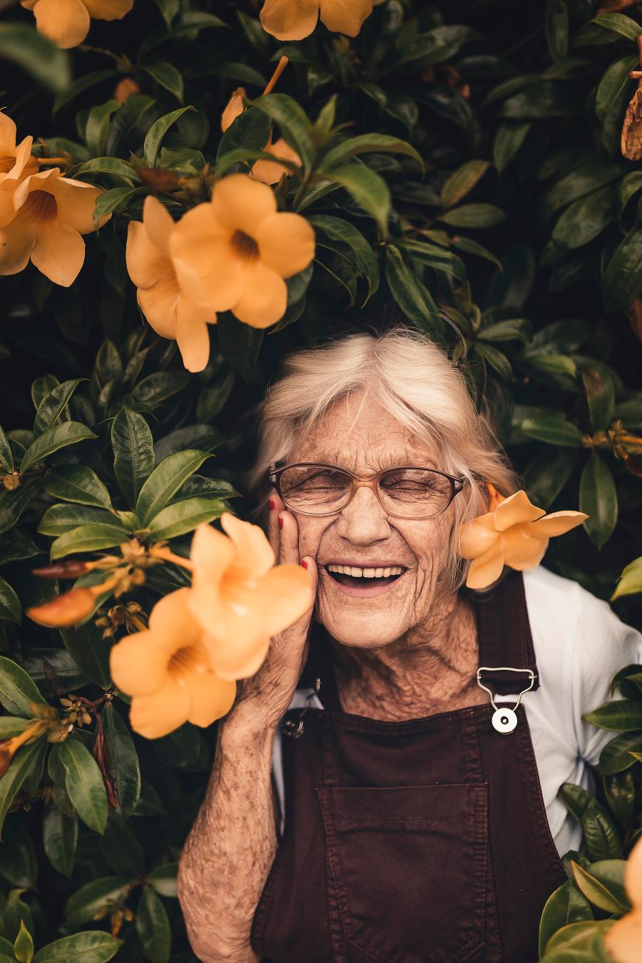 kvinde smiler i blomsterbusk