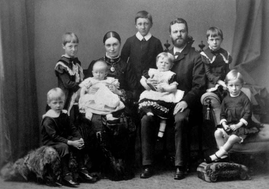 Sort/hvidt billede af 7 børn og deres forældre fra år 1885 